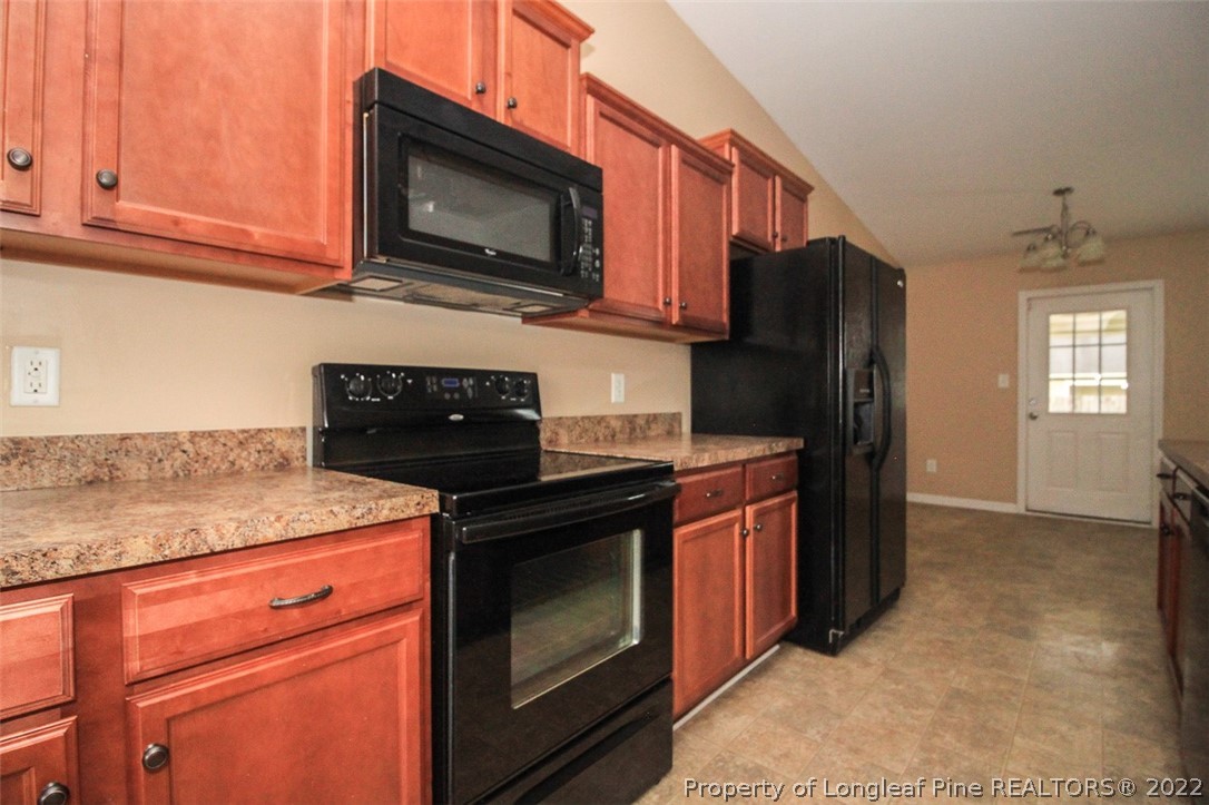 6377 Overhills Road Spring Lake, NC 28390 - Photo 14 of 29 a kitchen with stainless steel appliances granite countertop a stove microwave refrigerator and sink