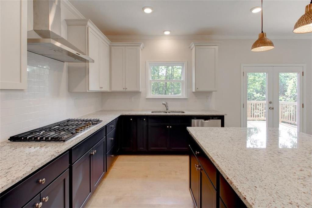 41 Woodland Road Covington, GA 30016 - Photo 27 of 46 a kitchen with granite countertop a sink a stove and cabinets