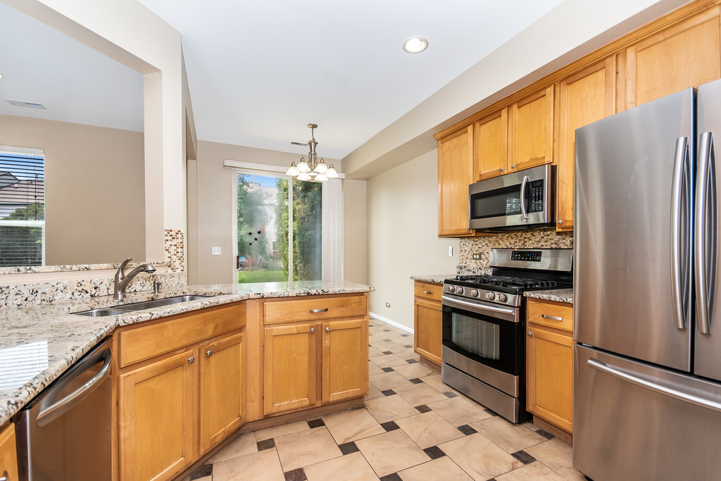 3160 Bromley Lane Aurora, IL 60502 - Photo 3 of 15 a kitchen with stainless steel appliances sink stove microwave and refrigerator