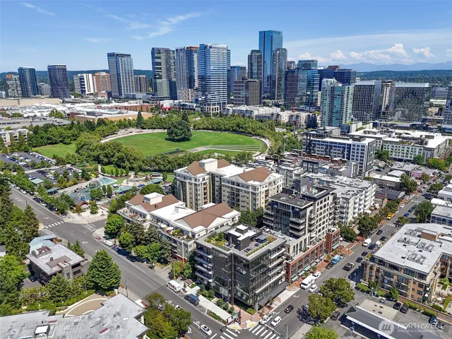 an aerial view of a city with lots of residential buildings ocean and mountain view in back