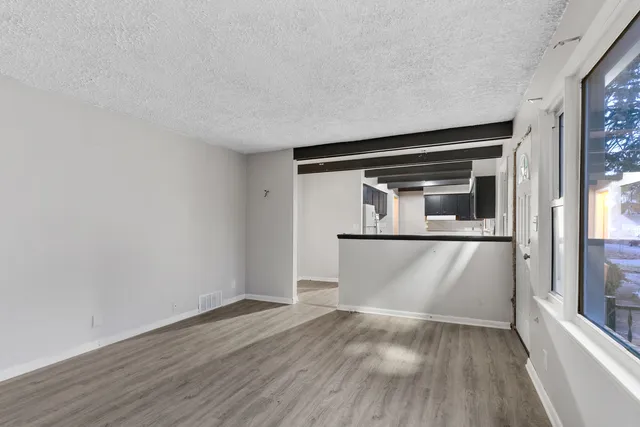a kitchen with a refrigerator a sink and wooden floor