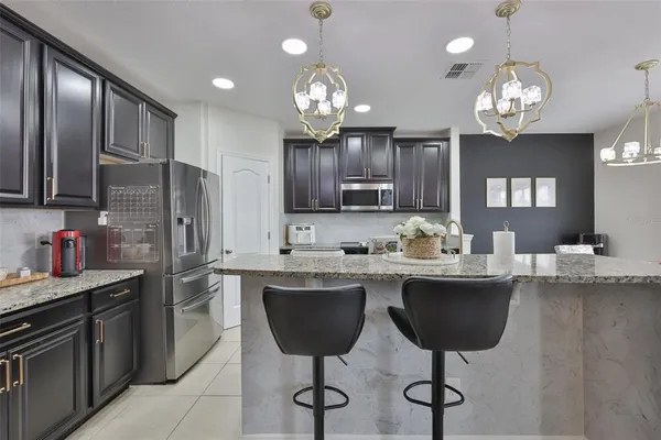 a kitchen with cabinets a sink stainless steel appliances and dining table