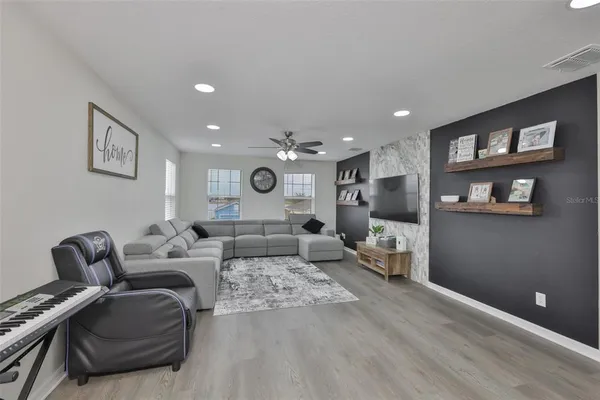 a living room with furniture and a wooden floor
