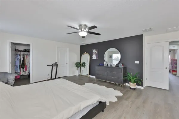 a bedroom with a bed and a dresser with mirror