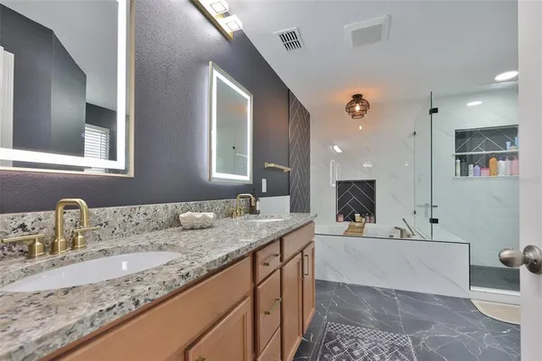 a bathroom with a sink double vanity granite and a mirror
