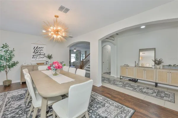 a dining room with wooden floor and a chandelier
