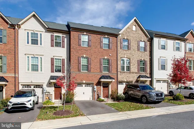 a front view of a building with cars parked