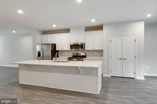 a view of kitchen with stainless steel appliances granite countertop a stove a sink a refrigerator and a microwave