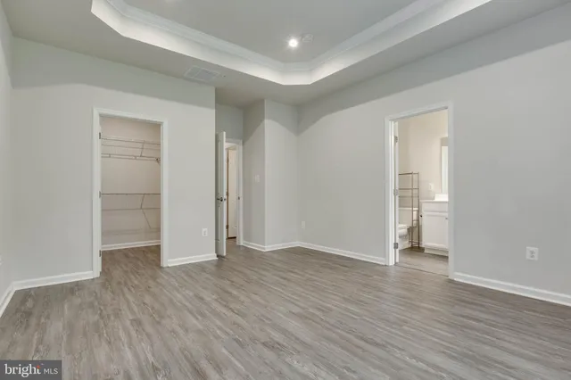 an empty room with wooden floor & closet and windows
