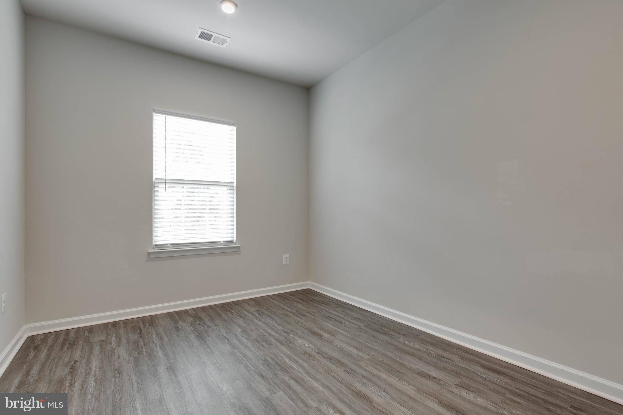 3004 Cornfield Avenue Hanover, MD 21076 - Photo 30 of 50 an empty room with wooden floor and windows
