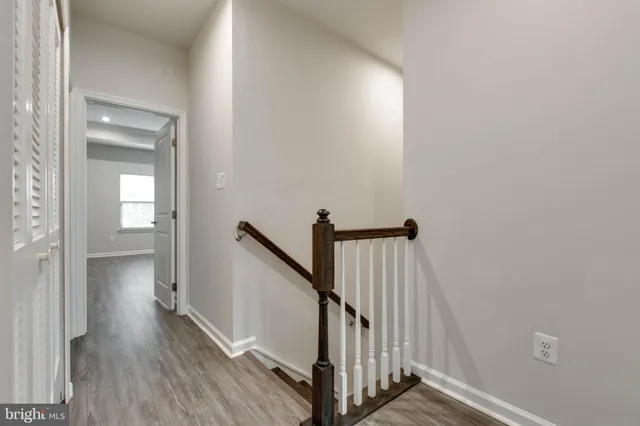 a view of a hallway with wooden floor and staircase