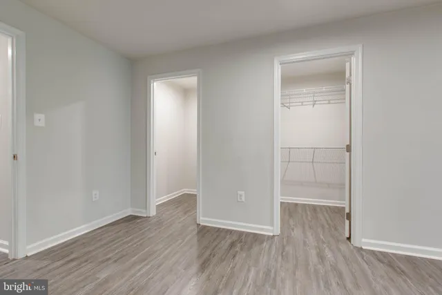 an empty room with wooden floor and closet