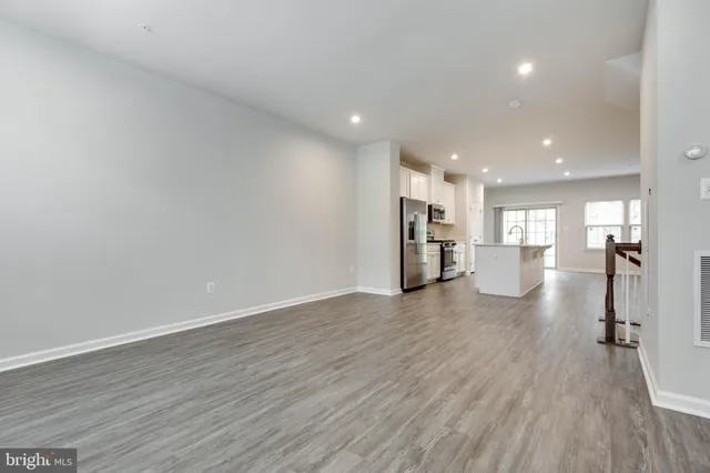 a view of a big room with wooden floors and kitchen view