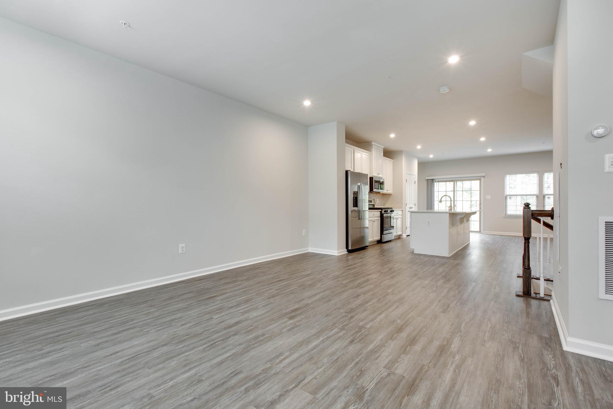 3004 Cornfield Avenue Hanover, MD 21076 - Photo 10 of 50 a view of a big room with wooden floors and kitchen view