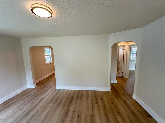 an empty room with wooden floor and mirror