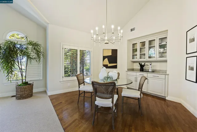 a kitchen with stainless steel appliances granite countertop a table chairs stove and refrigerator