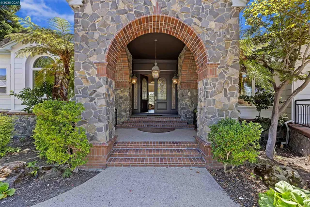 a view of a house with a yard and large tree
