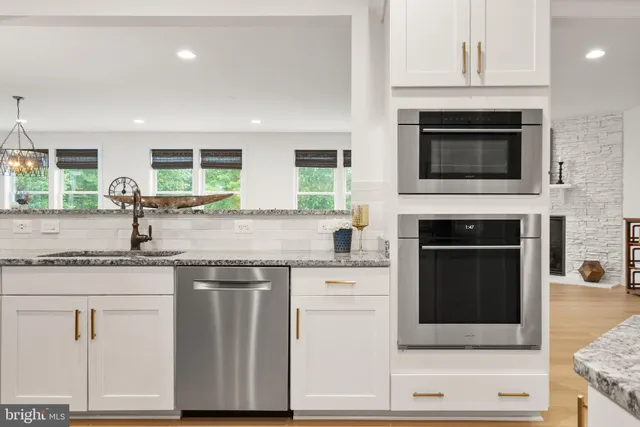 a kitchen with kitchen island a dining table chairs sink and cabinets