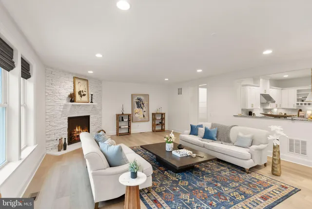 a view of a livingroom with wooden floor and kitchen space