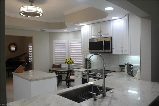 a kitchen with stainless steel appliances a stove a sink cabinets and a dining table