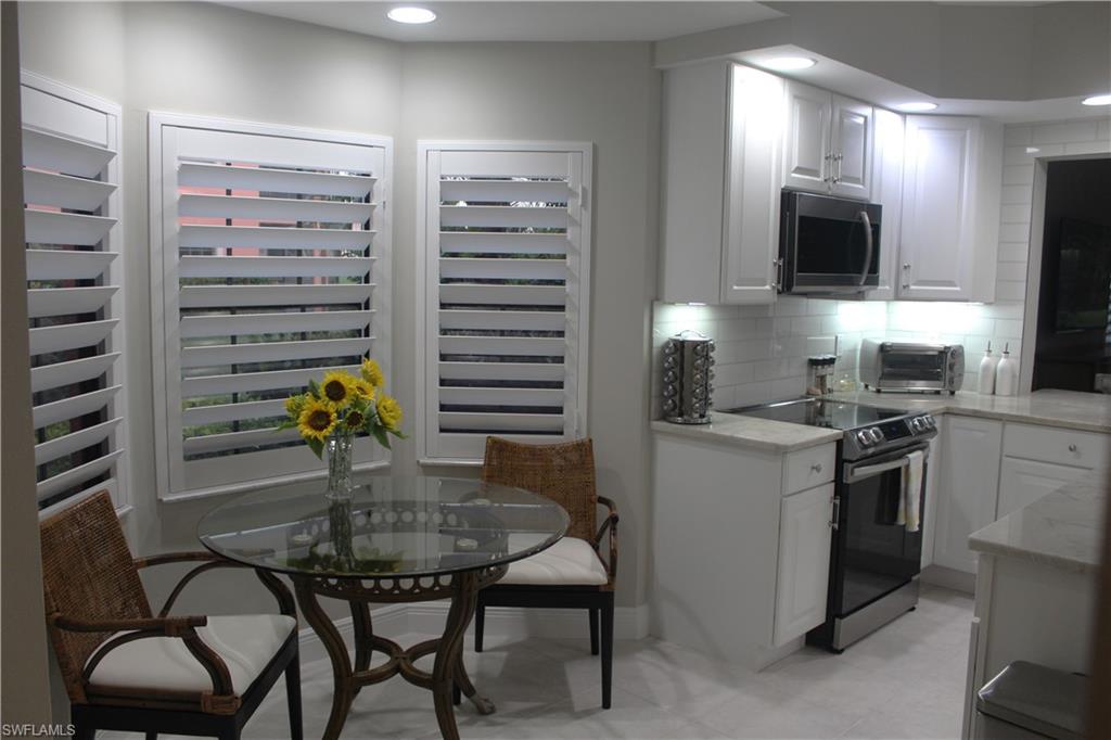 5770 Grande Reserve Way, Unit 1501 Naples, FL 34110 - Photo 4 of 18 a kitchen with a dining table and chairs