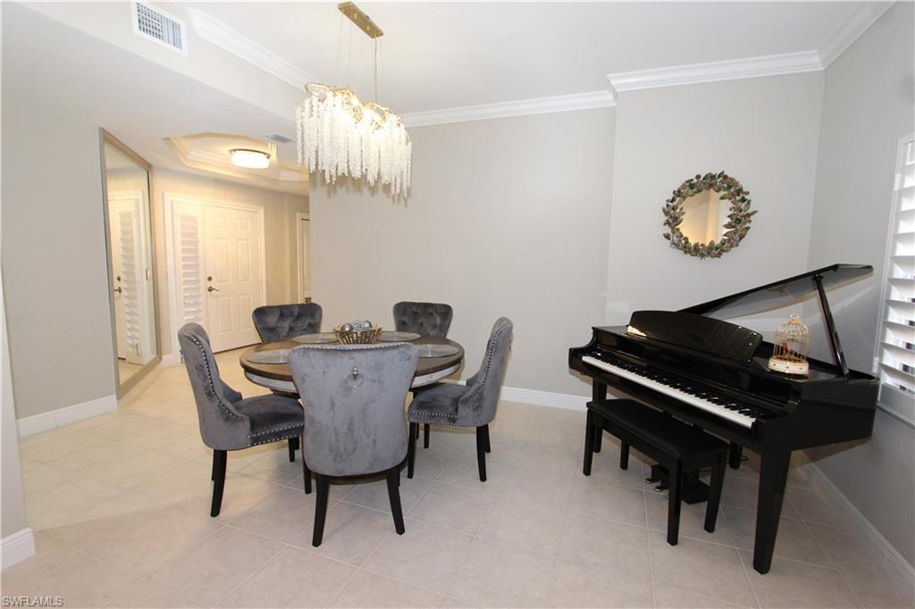 5770 Grande Reserve Way, Unit 1501 Naples, FL 34110 - Photo 5 of 18 a dining room with furniture and a chandelier