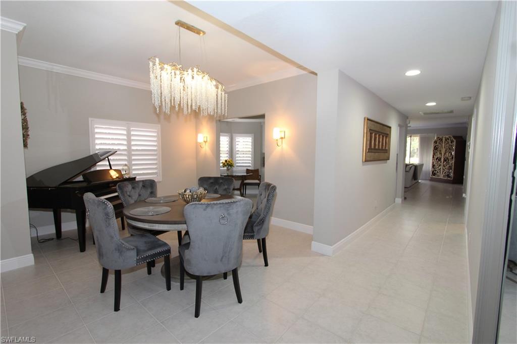 5770 Grande Reserve Way, Unit 1501 Naples, FL 34110 - Photo 6 of 18 a view of a dining room with furniture and chandelier