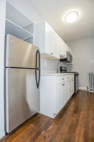a kitchen with a sink a refrigerator and cabinets