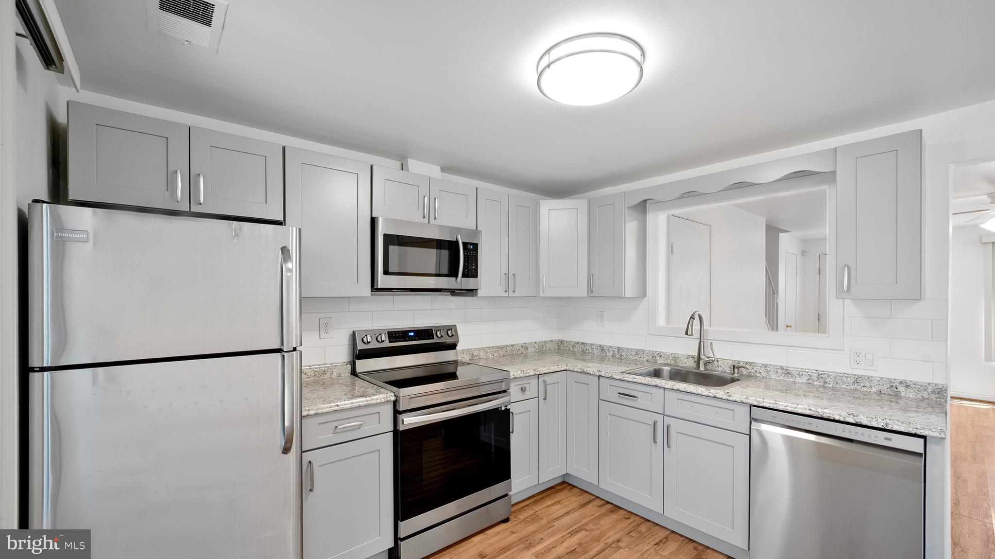 10710 Lester Street Silver Spring, MD 20902 - Photo 11 of 24 a kitchen with stainless steel appliances granite countertop cabinets and a refrigerator