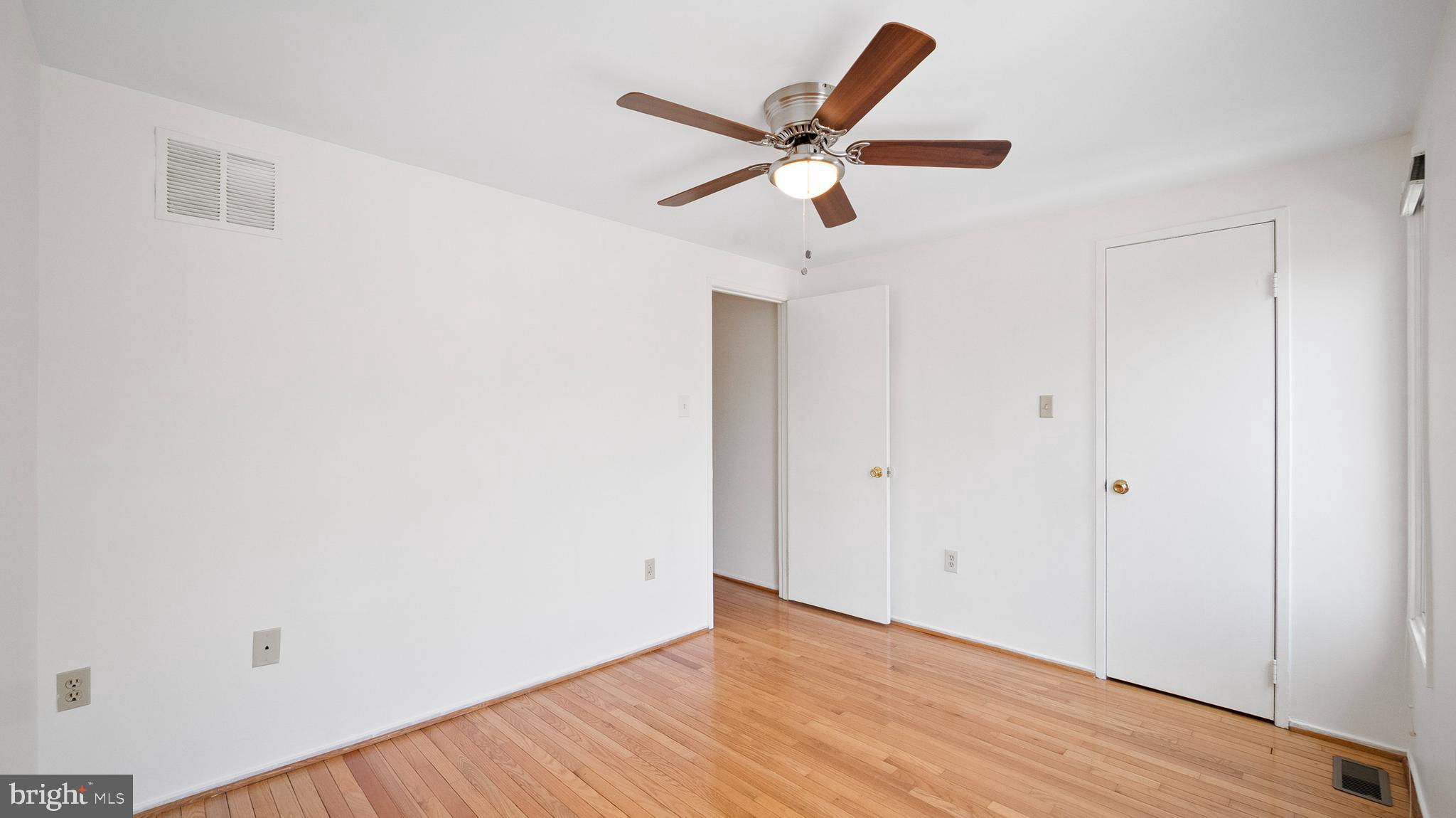 10710 Lester Street Silver Spring, MD 20902 - Photo 18 of 24 an empty room with wooden floor and a ceiling fan