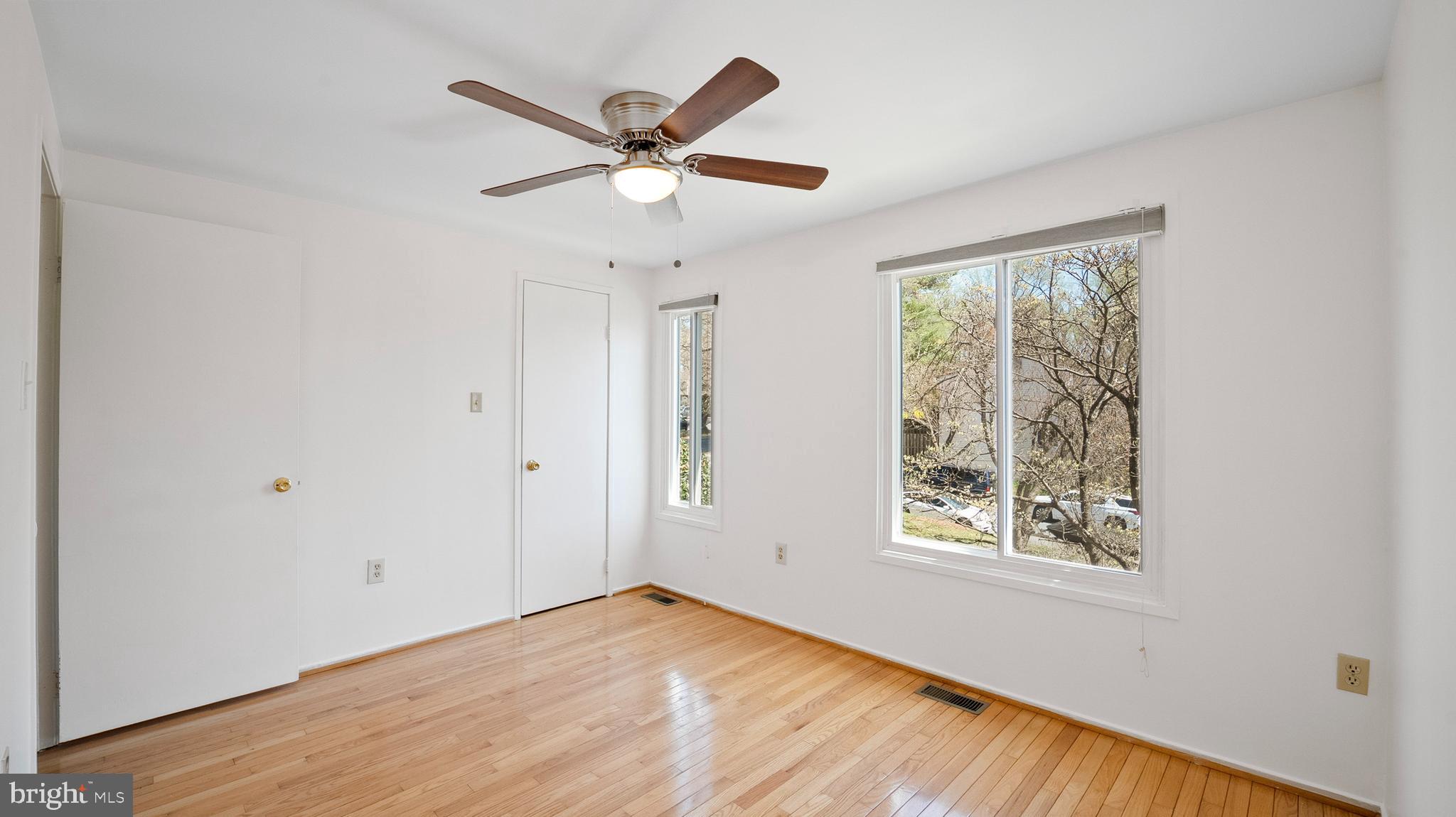 10710 Lester Street Silver Spring, MD 20902 - Photo 19 of 24 an empty room with wooden floor fan and windows