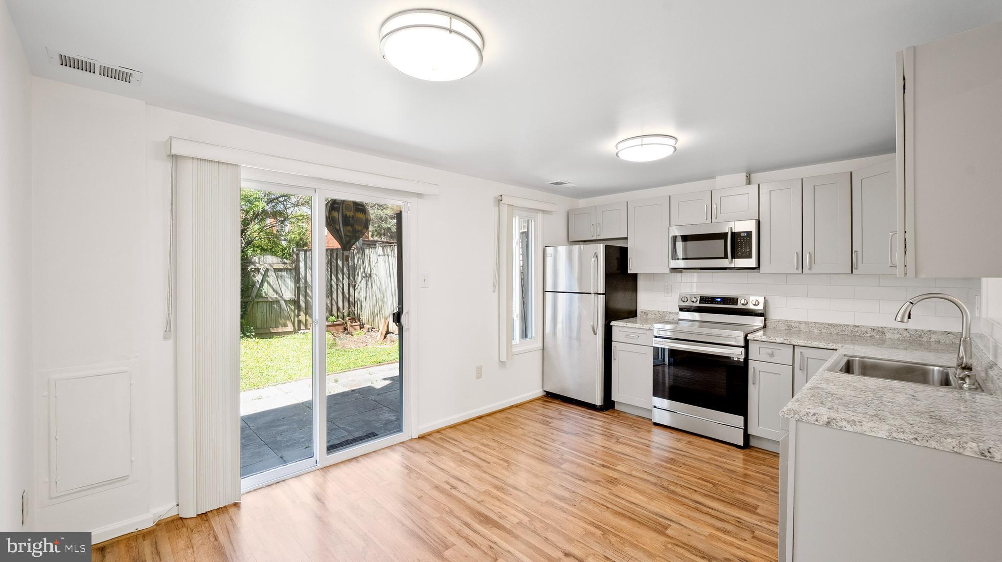 10710 Lester Street Silver Spring, MD 20902 - Photo 8 of 24 a kitchen with stainless steel appliances a refrigerator sink and stove