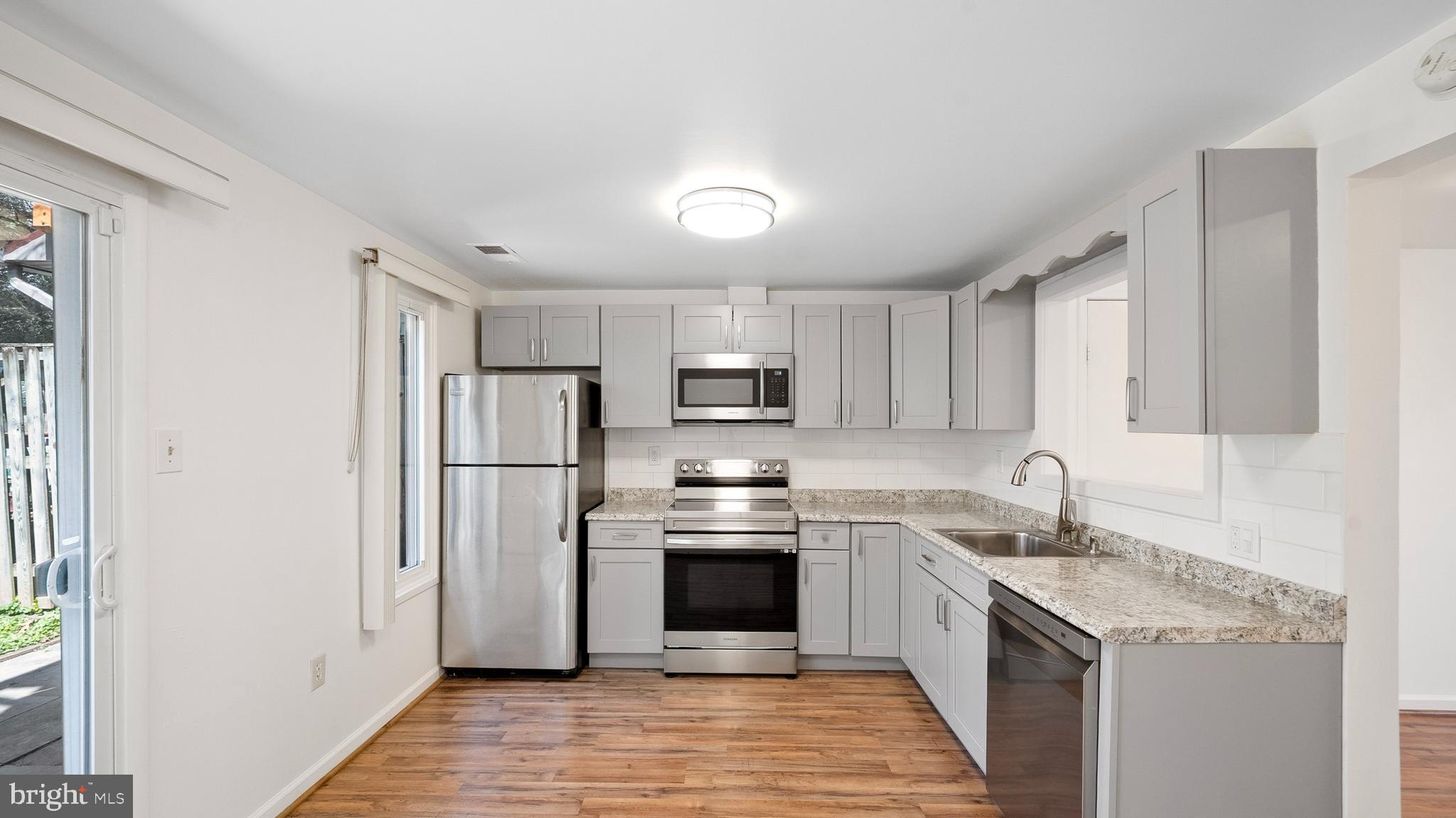 10710 Lester Street Silver Spring, MD 20902 - Photo 10 of 24 a kitchen with stainless steel appliances granite countertop a sink stove and refrigerator