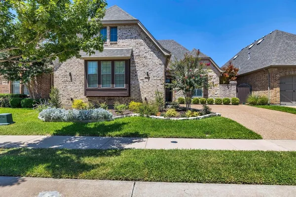 a front view of a house with a yard and potted plants