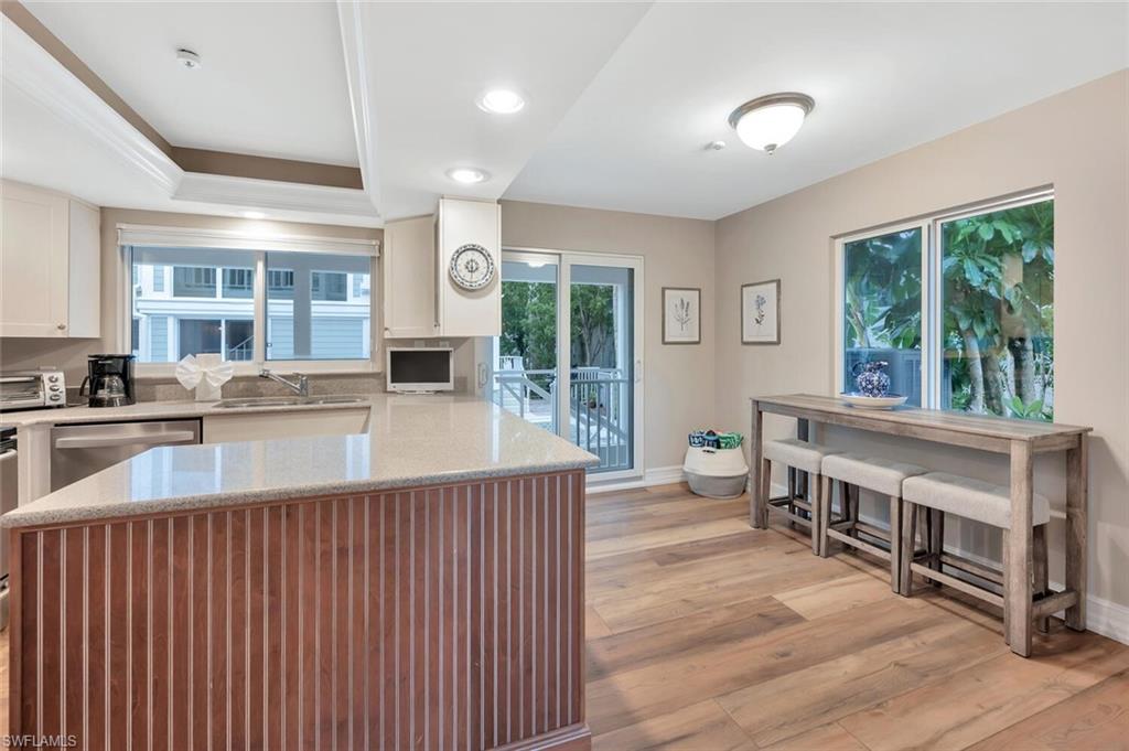 180 6th Avenue South, Unit 3 Naples, FL 34102 - Photo 11 of 44 a view of a kitchen with kitchen island a large window