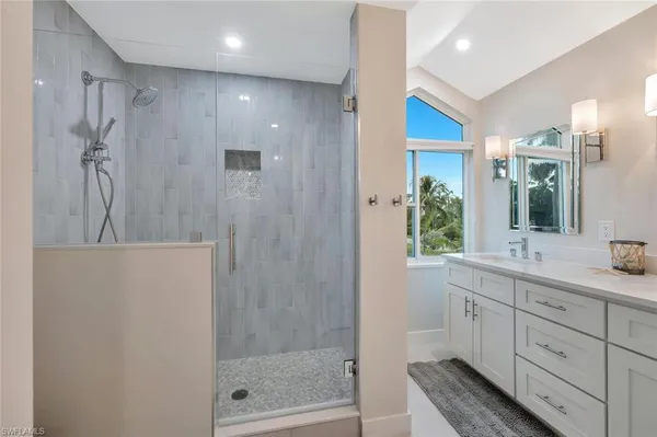 a bathroom with a double vanity sink and mirror with window