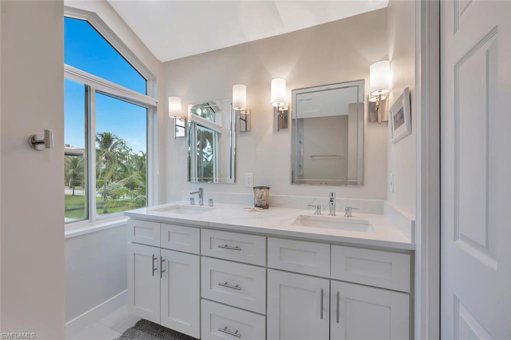 180 6th Avenue South, Unit 3 Naples, FL 34102 - Photo 25 of 44 a bathroom with a double vanity sink and mirror with window