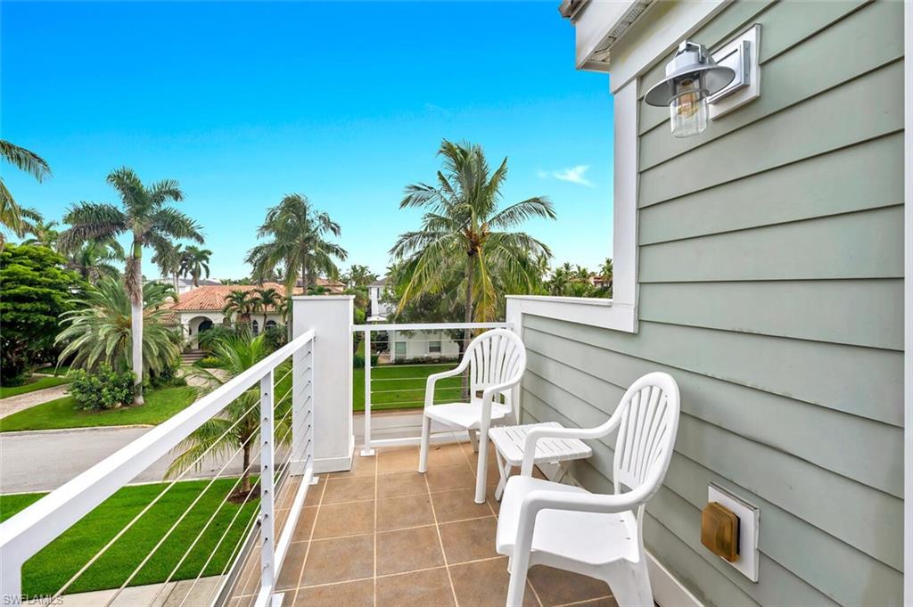 180 6th Avenue South, Unit 3 Naples, FL 34102 - Photo 37 of 44 a view of a chair and tables in the balcony