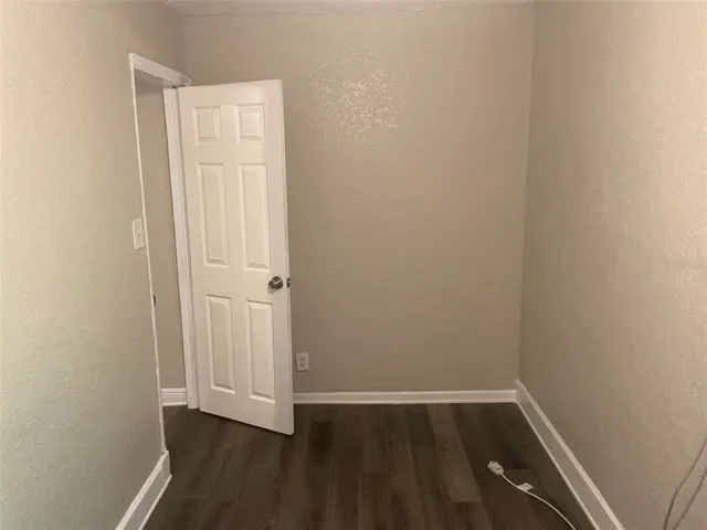 a view of a small space with wooden floor and a window