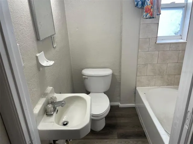 a bathroom with a sink a toilet and bathtub