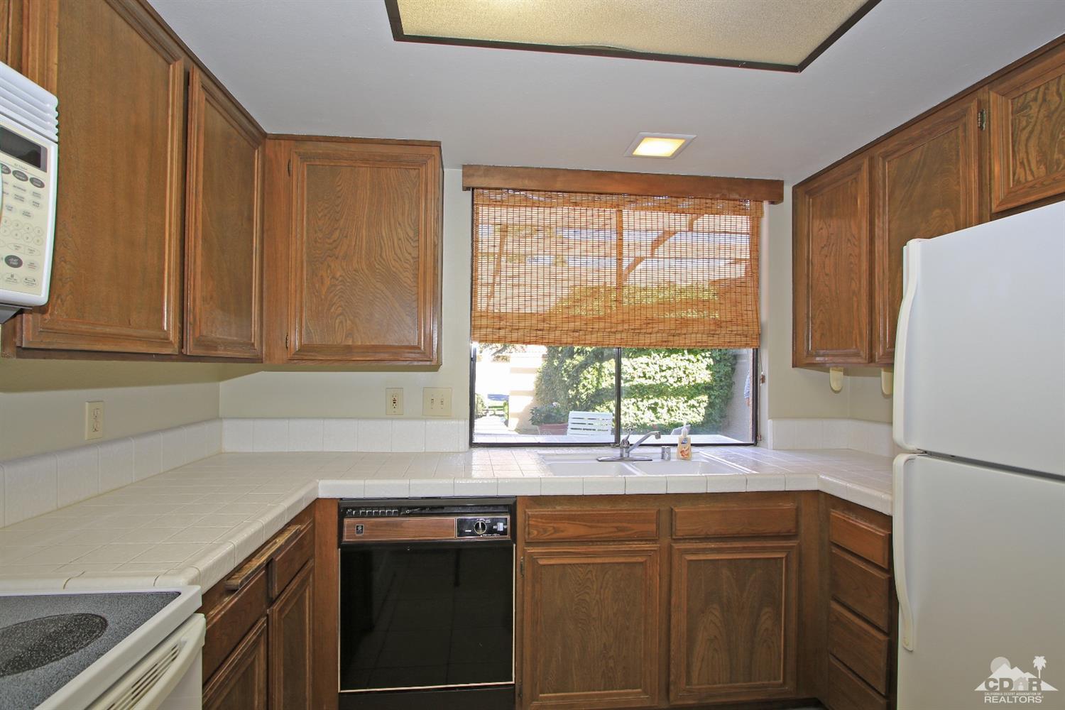 7 Palma Drive Rancho Mirage, CA 92270 - Photo 13 of 33 a kitchen with stainless steel appliances white cabinets and a window