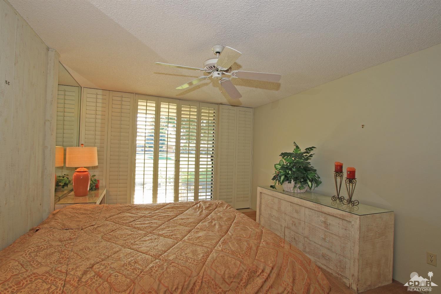 7 Palma Drive Rancho Mirage, CA 92270 - Photo 22 of 33 a bedroom with a bed and a chandelier