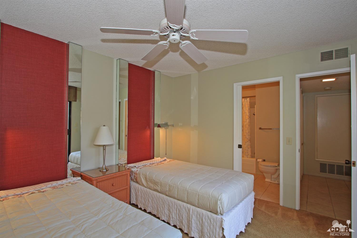 7 Palma Drive Rancho Mirage, CA 92270 - Photo 27 of 33 a bedroom with a bed and a chandelier