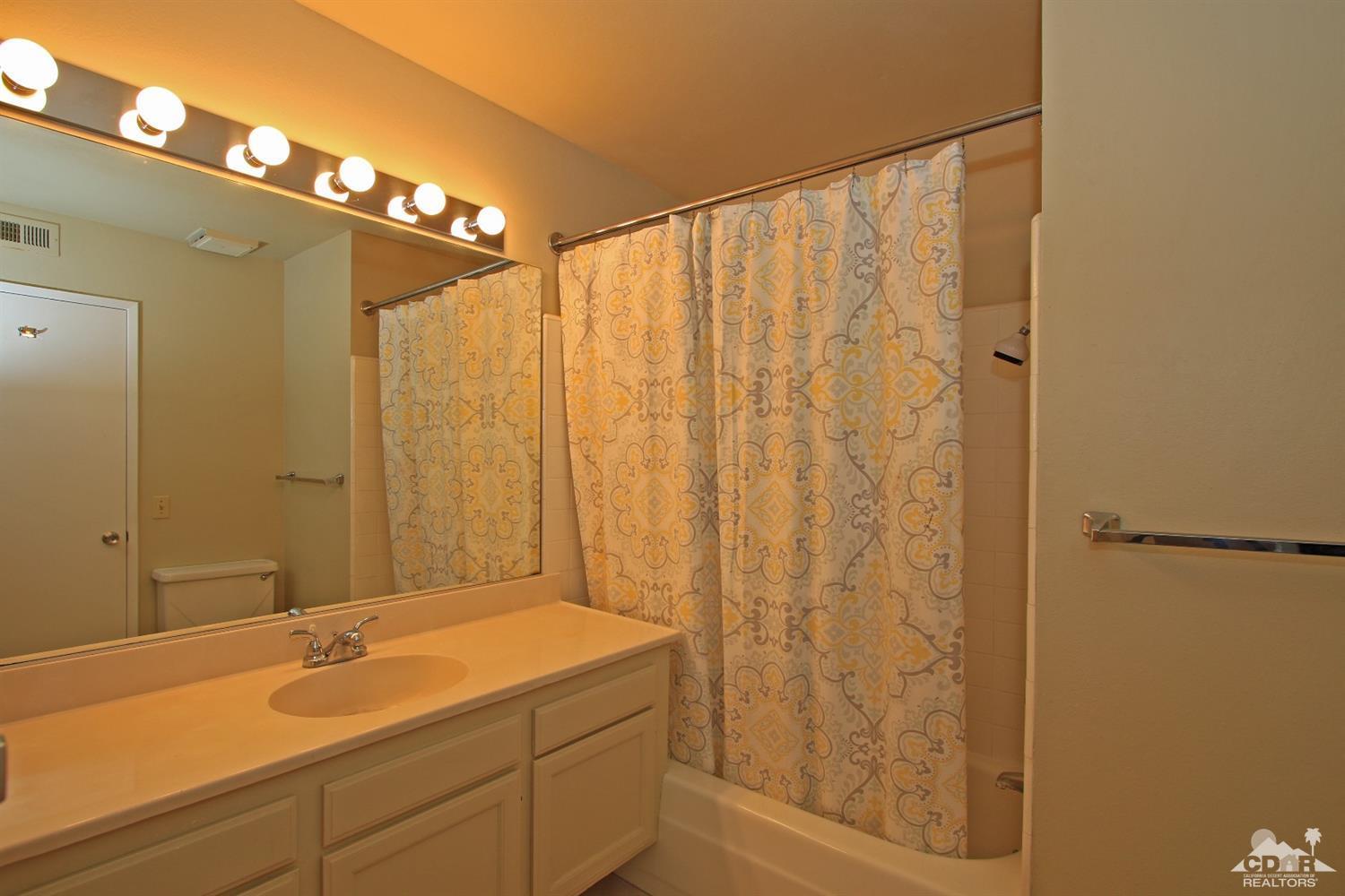 7 Palma Drive Rancho Mirage, CA 92270 - Photo 28 of 33 a bathroom with a granite countertop sink and a shower