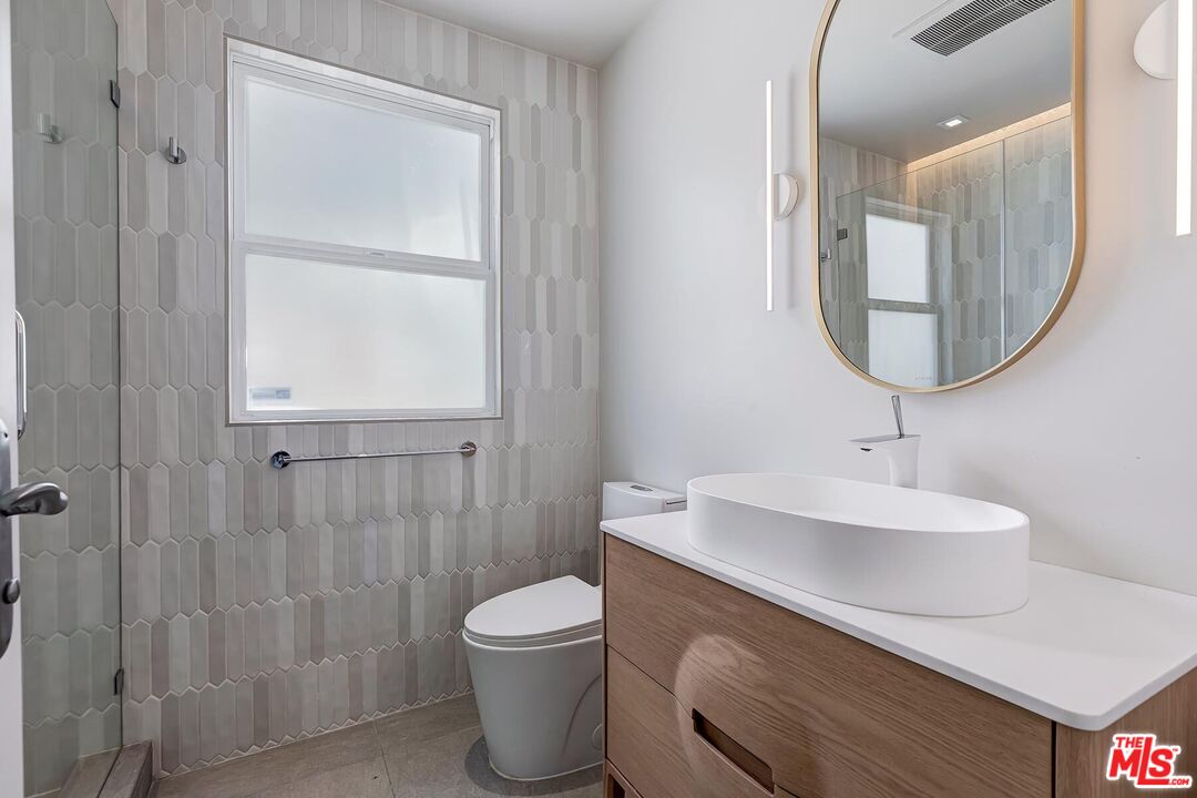 2203 Bowmont Drive Beverly Hills, CA 90210 - Photo 12 of 21 a bathroom with a sink a toilet and a mirror