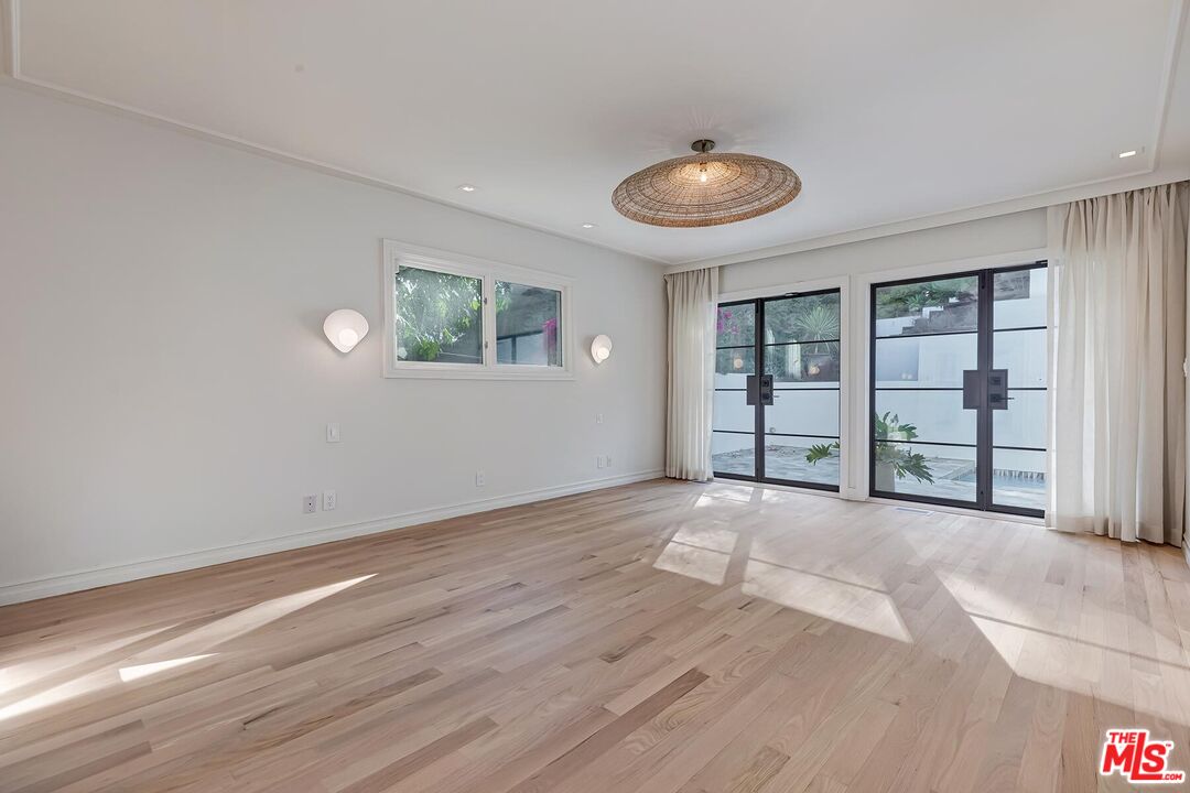 2203 Bowmont Drive Beverly Hills, CA 90210 - Photo 14 of 21 an empty room with wooden floor and windows