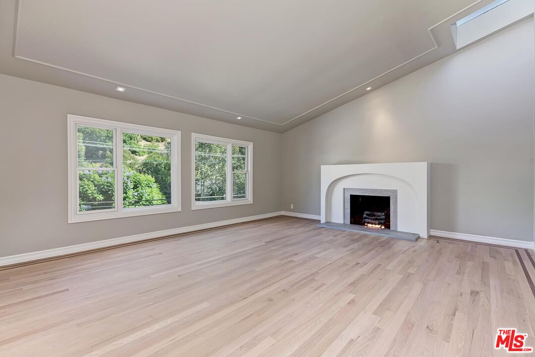 2203 Bowmont Drive Beverly Hills, CA 90210 - Photo 4 of 21 a view of empty room with wooden floor and fireplace