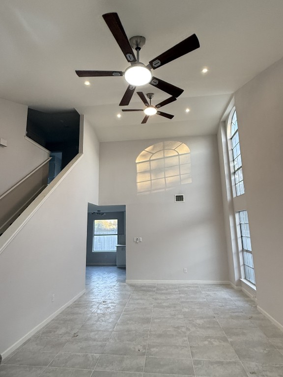 en empty room with windows and ceiling fan