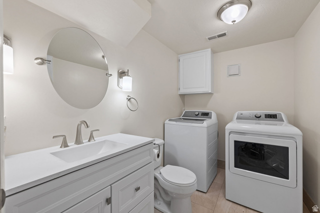2370 Quail Run Circle East Sandy, UT 84093 - Photo 29 of 54 Laundry room featuring a white vanity with integrated sink, brushed nickel fixtures, an oval mirror, and a toilet
