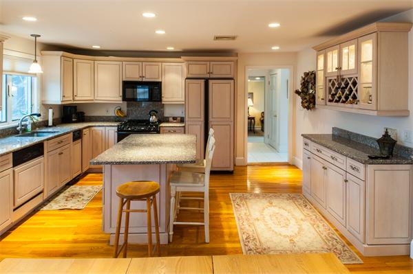 4 Buchanan Road Marblehead, MA 01945 - Photo 4 of 11 a kitchen with stainless steel appliances granite countertop a stove top oven a sink a dining table and chairs